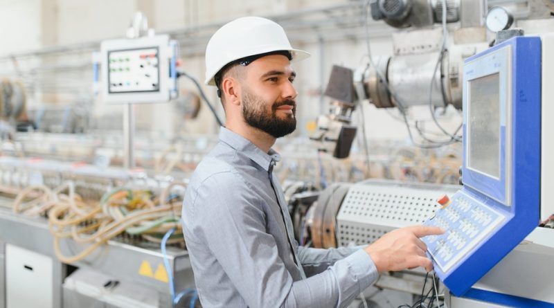 Engineer with iPad studying production line