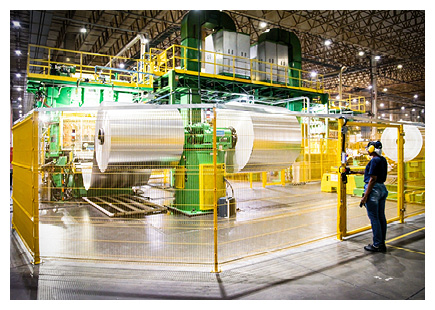 an industrial metal cold rolling mill featuring large cylindrical coils of sheet metal