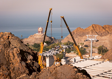 a construction site located in a mountainous, coastal region under a clear, haze-filled sky