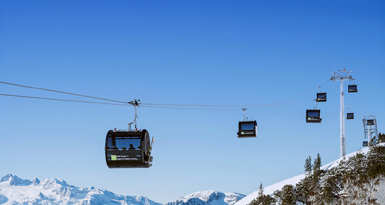 a cable car system operating on a bright, sunny winter day