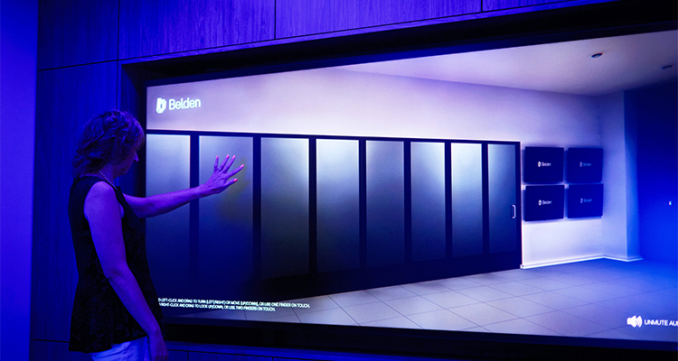a woman interacting with a large digital display in a room with striking blue lighting