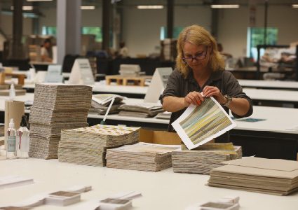 a person inspecting wallpaper or fabric strike-offs or samples