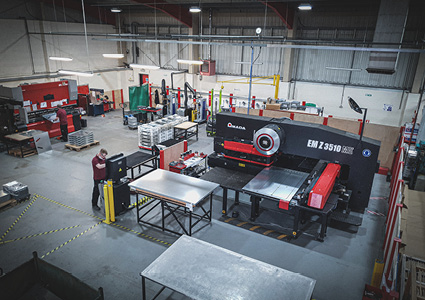 an overhead, wide-angle view of a spacious manufacturing factory floor where metal fabrication is taking place